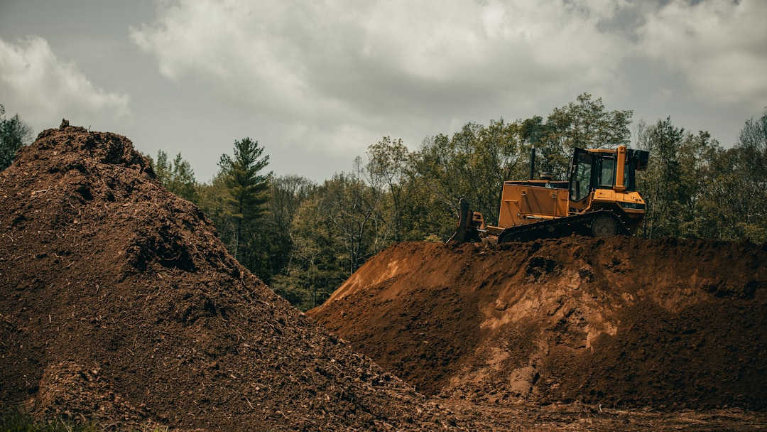 yellow-and-black-heavy-equipment-on-brown-rocky-hill-under-white-cloudy-sky-during-daytime-px66y31doiq